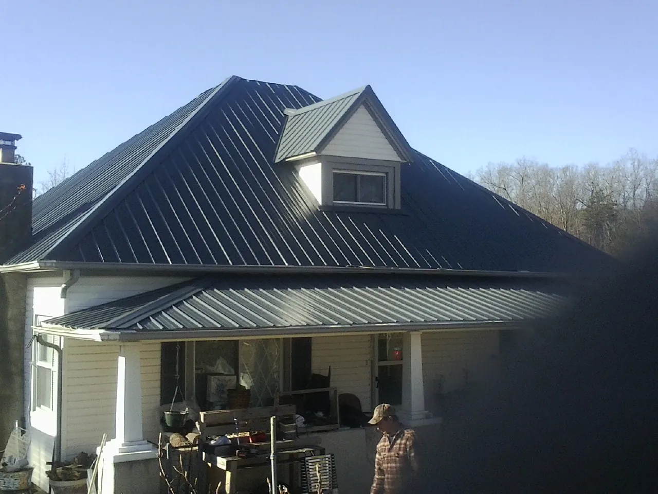 Dark blue standing seam metal roof with a dormer above a front porch in Manahawkin