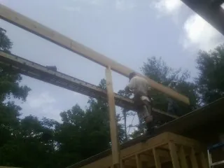 Carpenter setting a ridge beam over a new addition frame — Ice Dam Removal by Roofing Brothers in Manahawkin