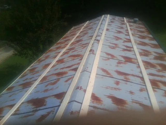 Rusted metal roof panels with new wood purlins before replacement — Storm Damage Roof Repair in Manahawkin by Roofing Brothers
