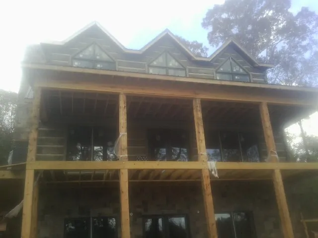 Dormers and porch framing on a large log home under construction — Roof Coating work by our crew in Manahawkin