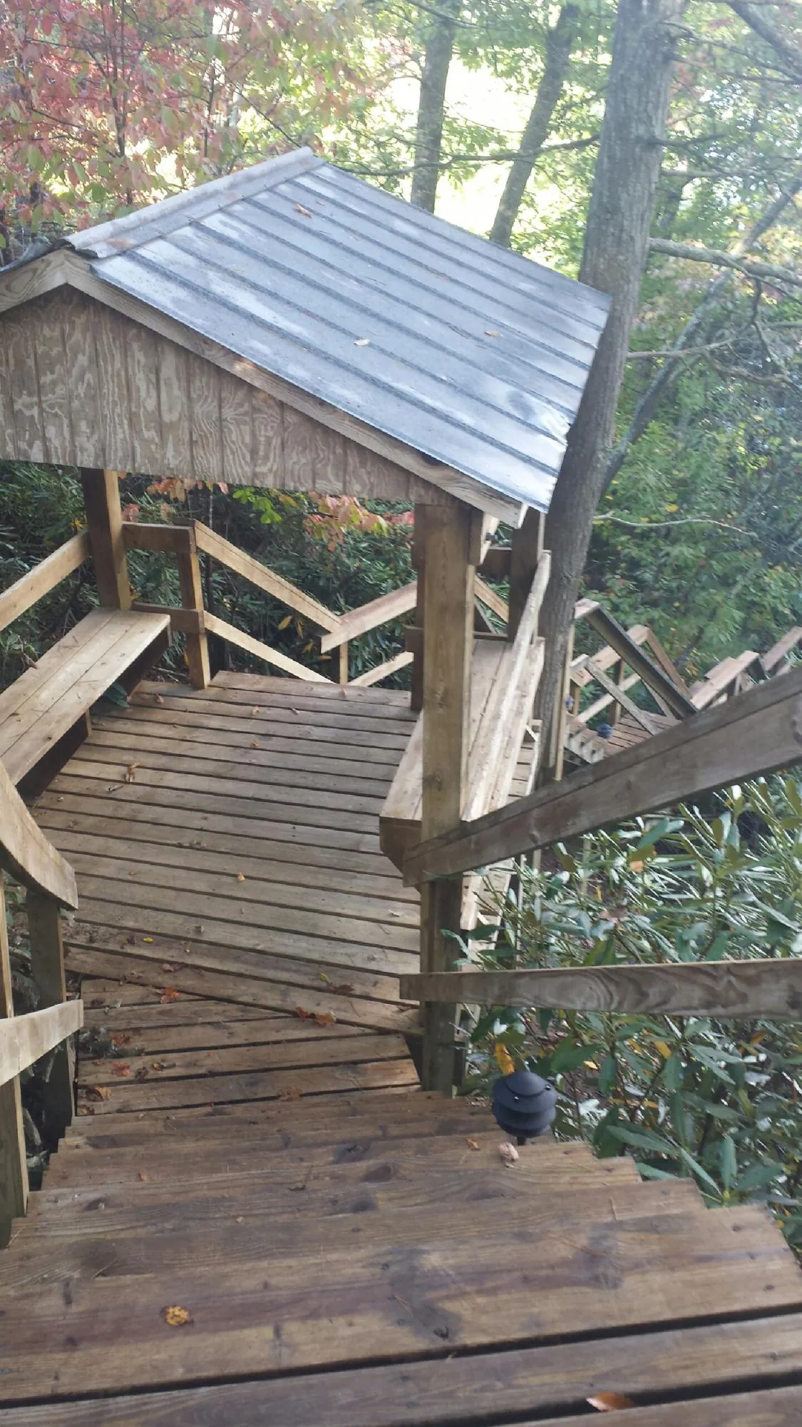 Metal roofed shelter over wooden steps on a wooded walkway — Skylight Repair & Installation work by our crew in Manahawkin